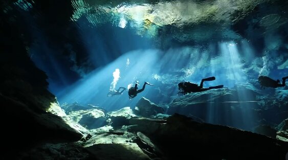 Snorkeller floating above submerged rock formations in a cenote
